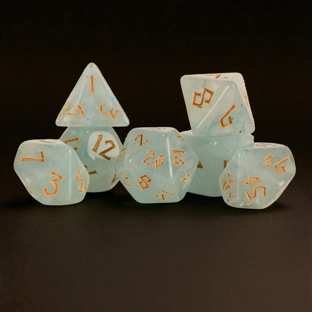 A set of pale jade acrylic dice with gold numbering