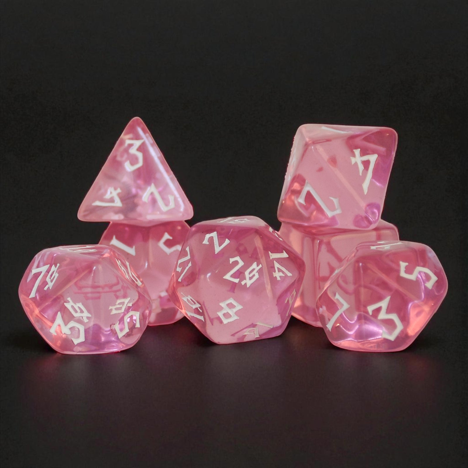 Pink clear acrylic dice set with white numbering in a nordic font for tabletop roleplaying games