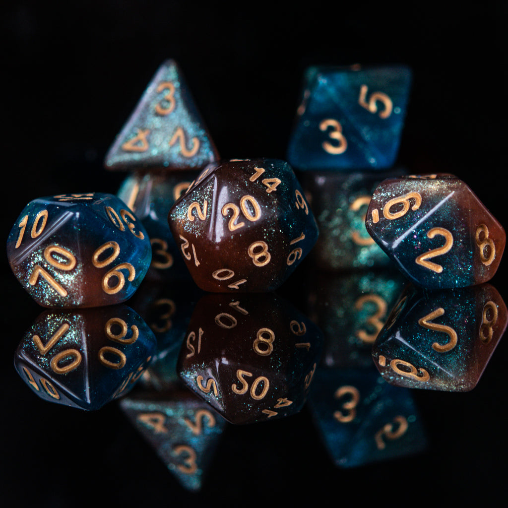 A set of acrylic dice featuring a mix of shimmering blue and orange colors with gold simple numbering for playing tabletop games and board games
