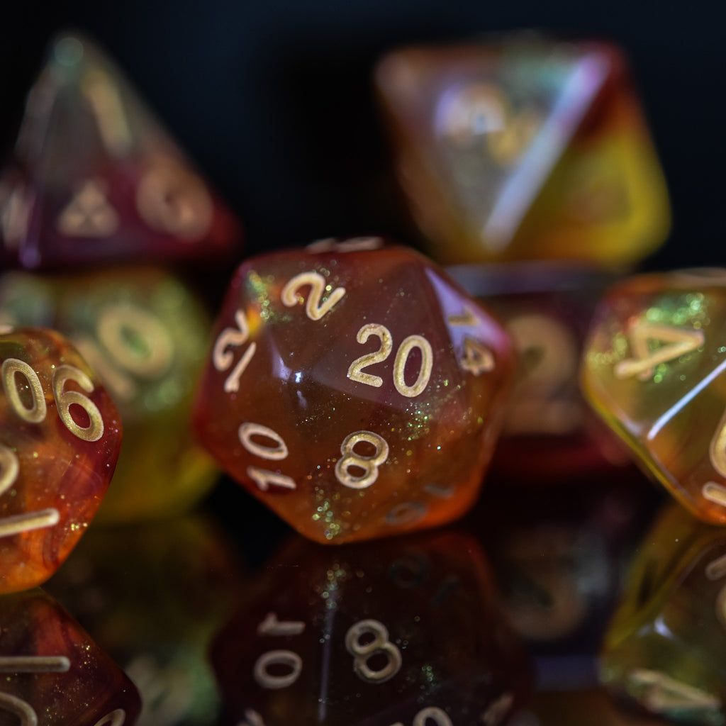 A set of shimmering orange acrylic dice with engraved gold numbers