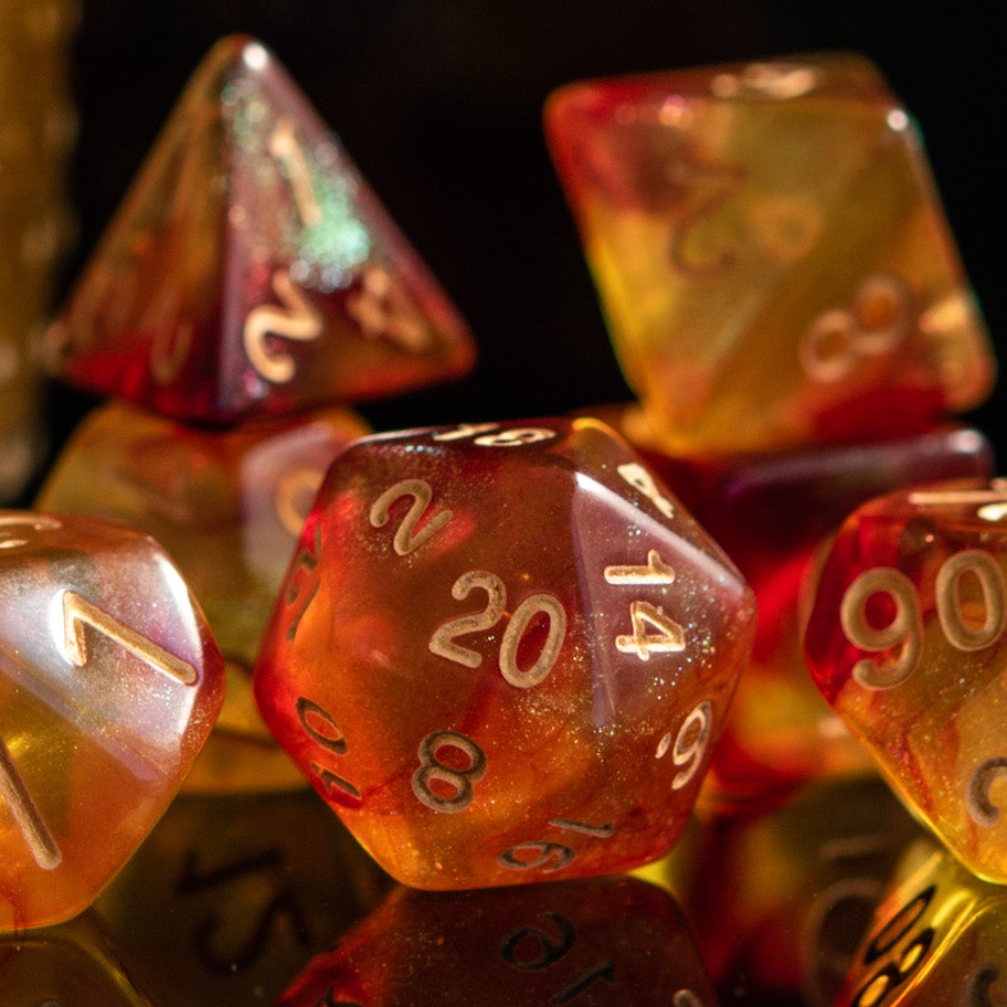 A set of shimmering orange acrylic dice with engraved gold numbers, displayed next to a bottle-shaped container 