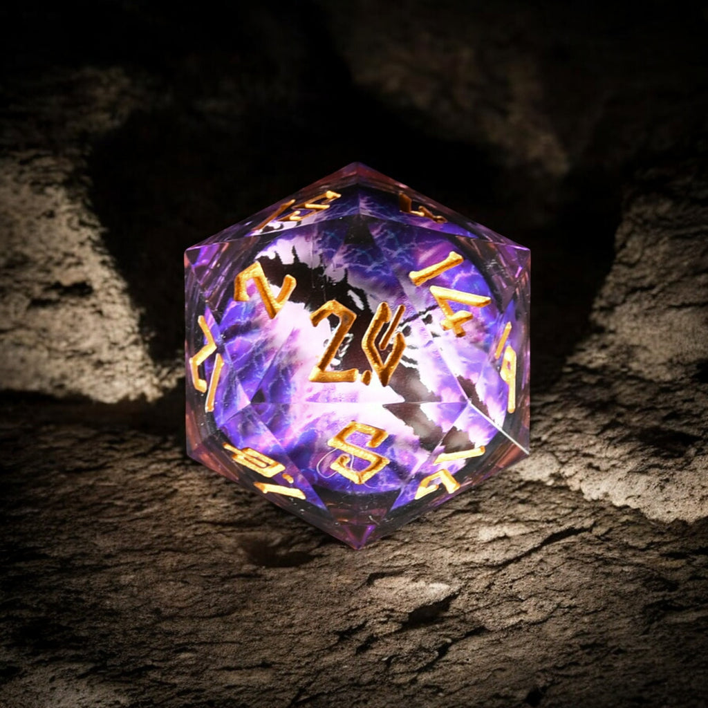 A purple and gold colored, resin-cast, 50mm D20 dice with engraved numbers, appearing to have a floating eyeball in the center, placed on a textured surface.