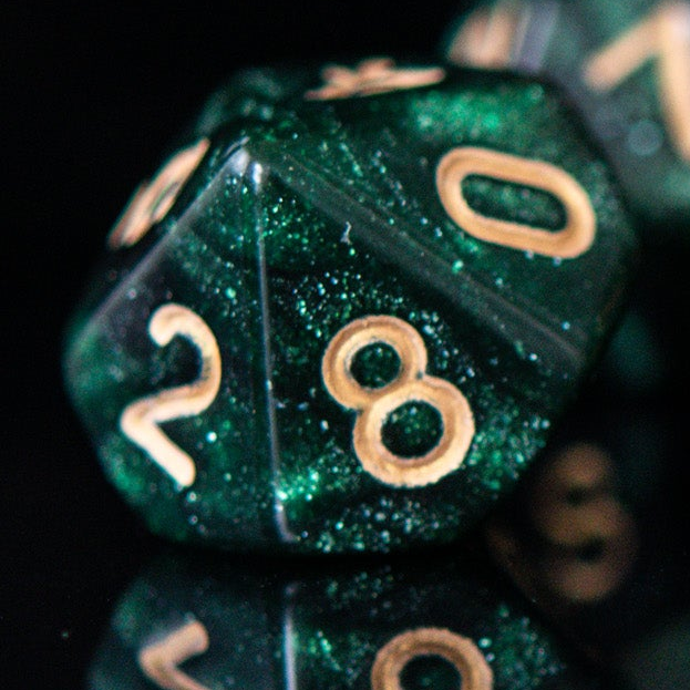 Green glittery polyhedral dice with gold numbers on a black background