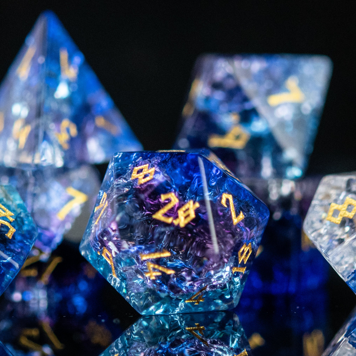 A set of hand-carved, multicolored glass dnd dice with engraved numbers, displaying a shattered glass effect.