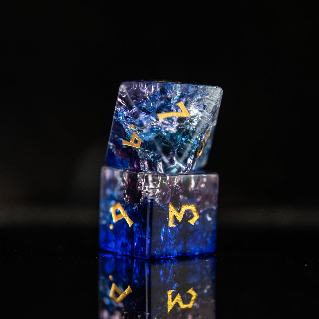 A set of hand-carved, multicolored glass dnd dice with engraved numbers, displaying a shattered glass effect.