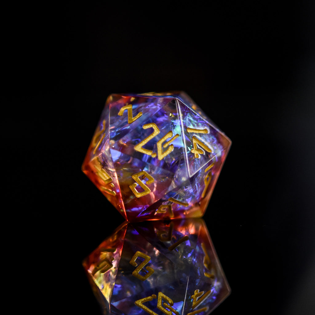 A set of sharp-edged resin dice with engraved numbers, featuring a translucent appearance with gold, orange, and purple colors.