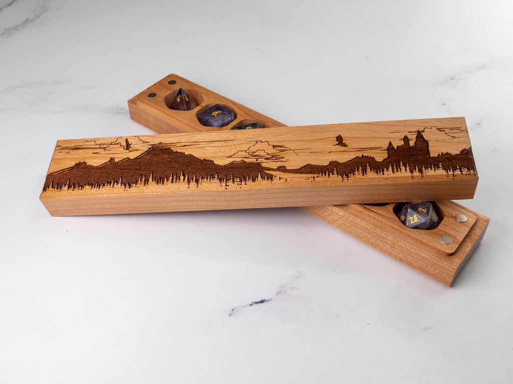 Wooden dice trays with laser-engraved designs on a white marble surface