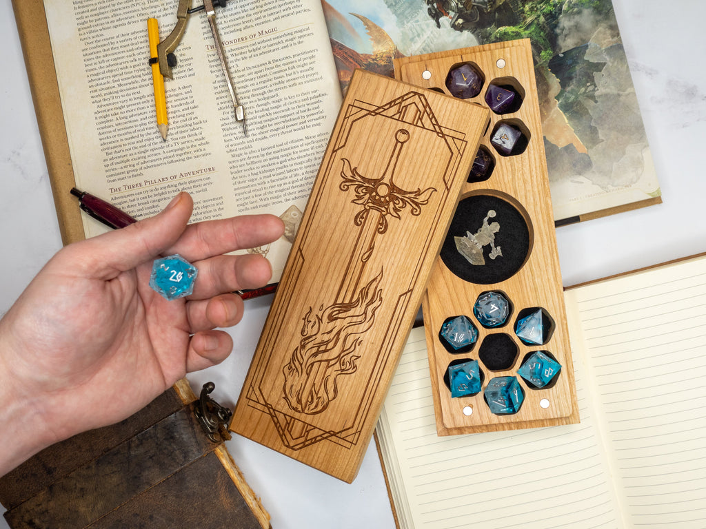 Wooden dice tray with engraved design and dice, held by a hand over an open book.