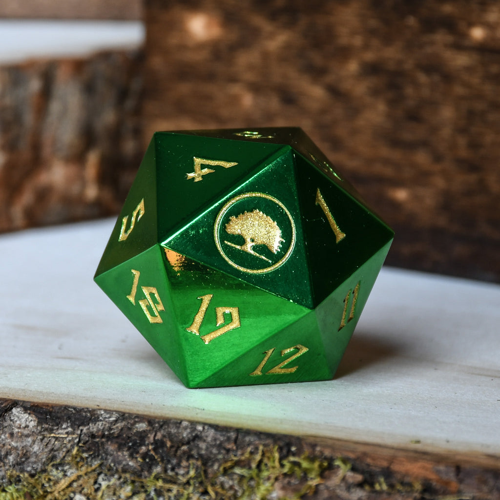 A green metal d20 spindown dice with numbers and a symbol on it, placed on a white surface with a wooden background.