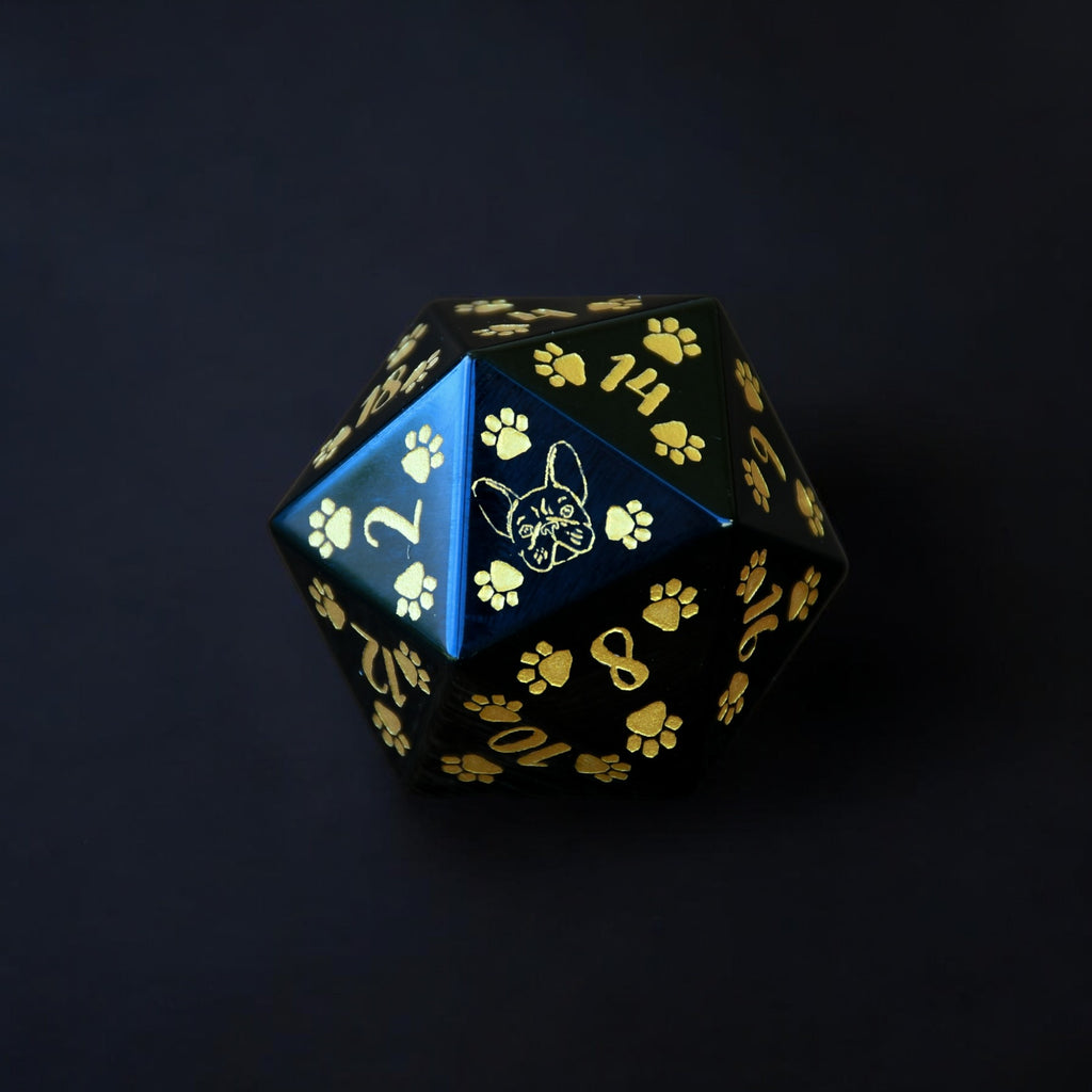 A black 30mm obsidian D20 dice with gold puppy paw prints and numbers