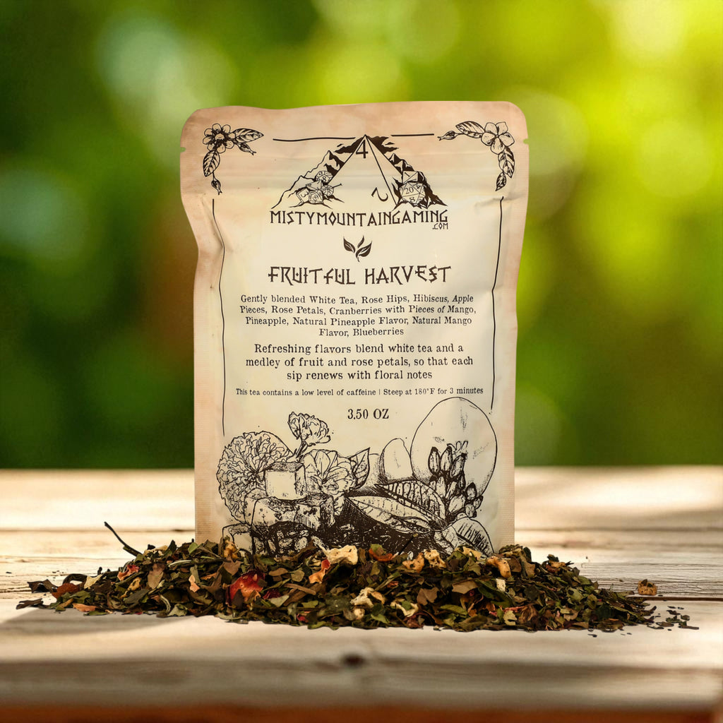 Misty Mountain Gaming Tea bag labeled 'Fruitful Harvest' with tea leaves on a wooden surface