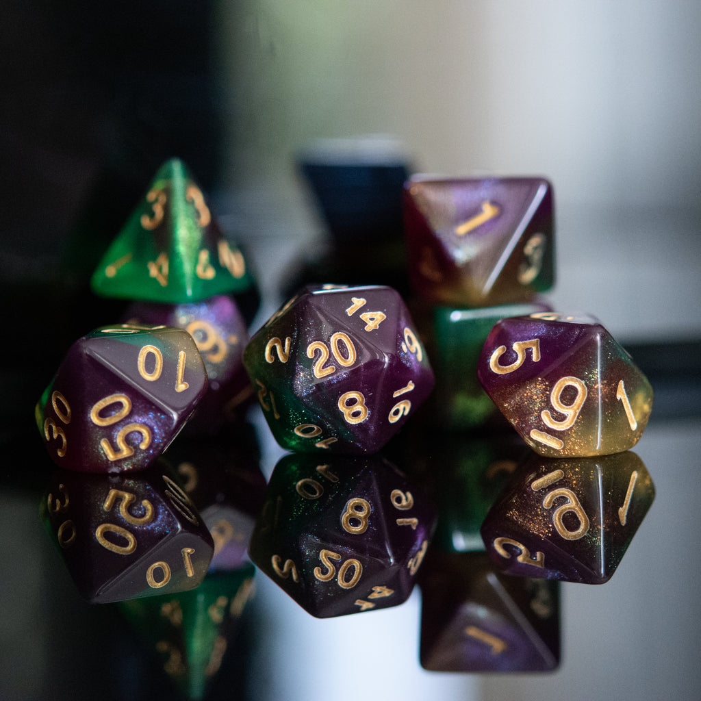 Close-up of polyhedral dice with gold numbers on a reflective surface.