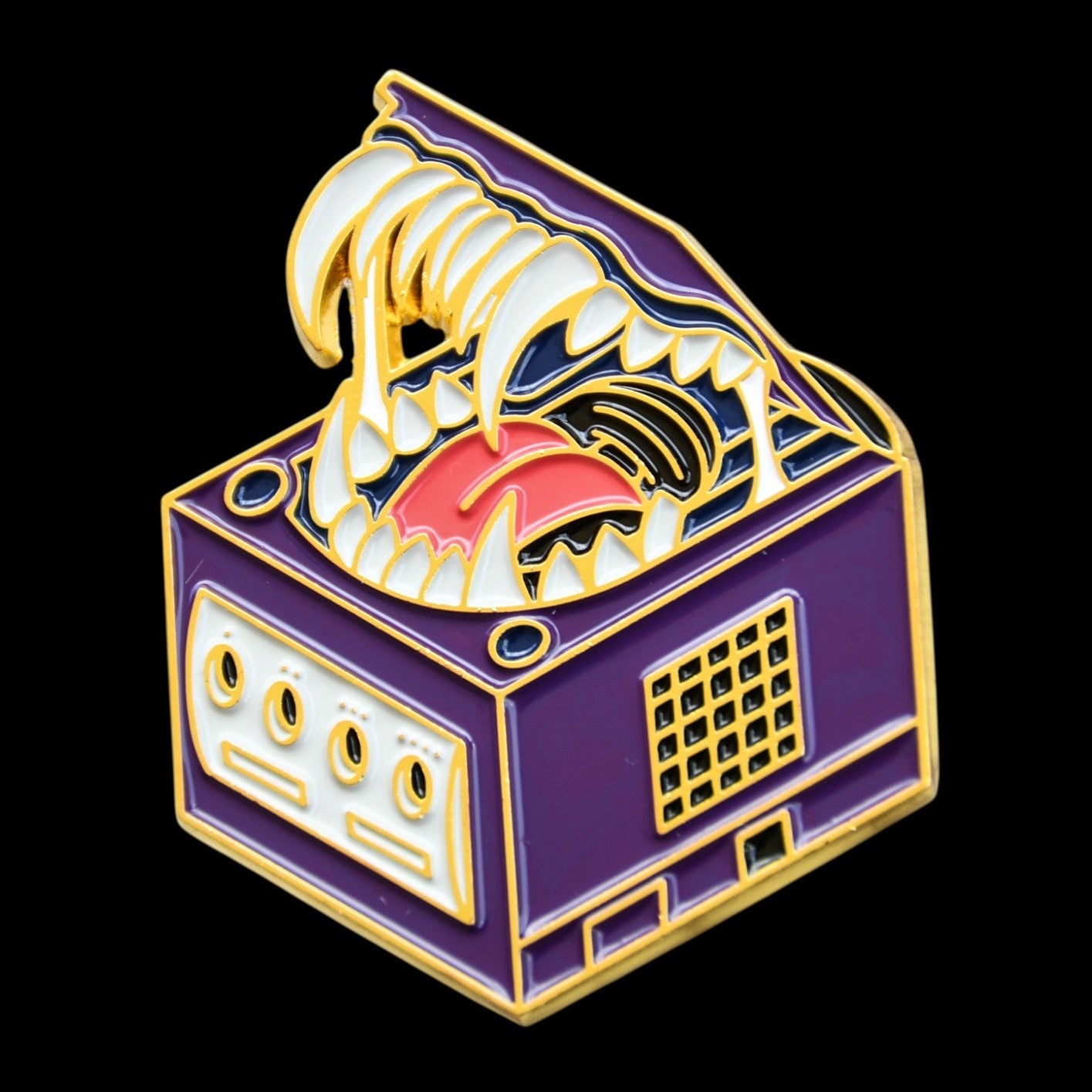 Enamel pin of a gamecube as a mimic with a stylized design on a black background