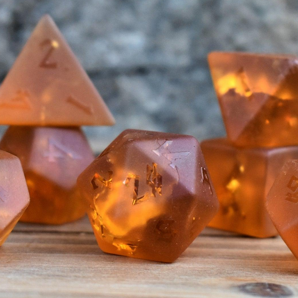 a set of 7 polyhedral dnd dice called Gates of Helheim Raised Lava Glass Dice on orange shattered matte glass with clear numbering 