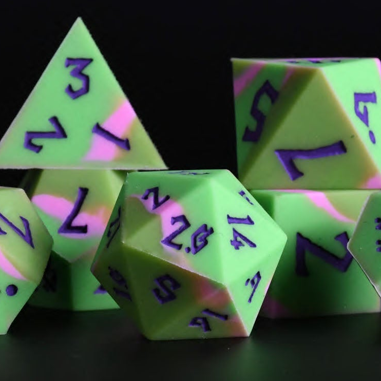 A set of silicone dice in various shapes including a D4, D6, D8, D10, D12, and D20, with green coloring and purple numbers. The dice are displayed against a dark background.
