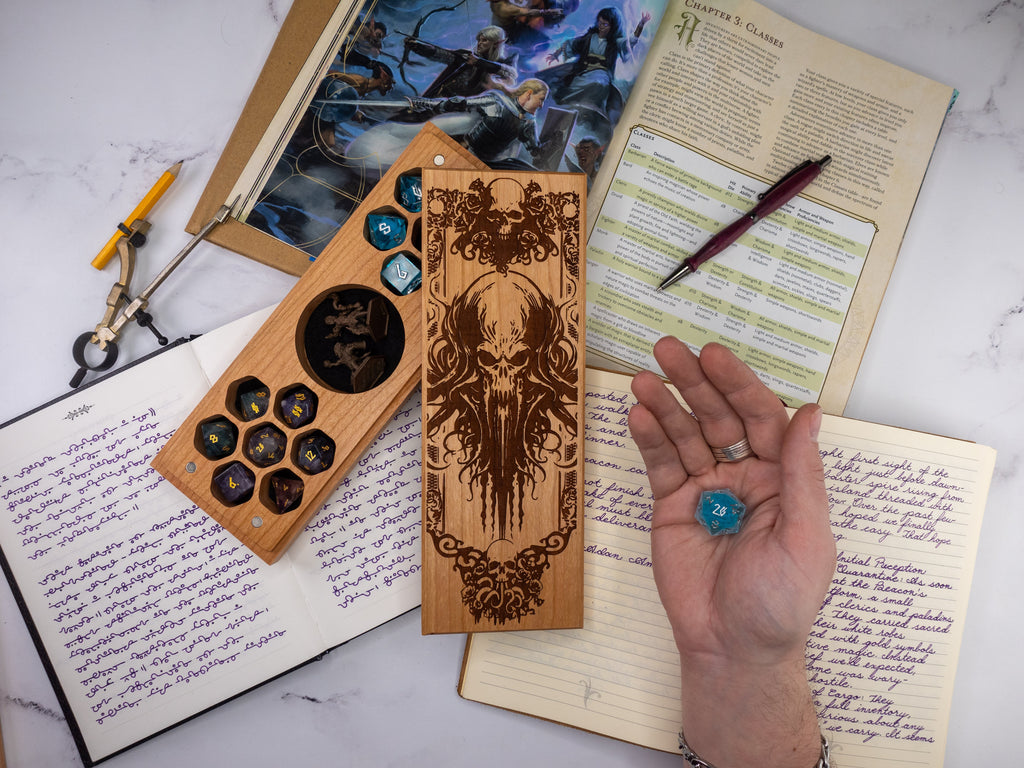 Person holding a blue die over a table with gaming supplies including dice sets and notebooks.