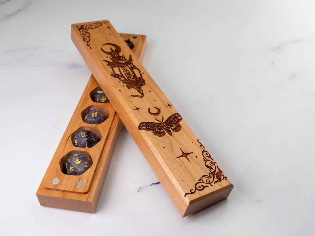 Wooden dice tray with engraved designs on a white surface