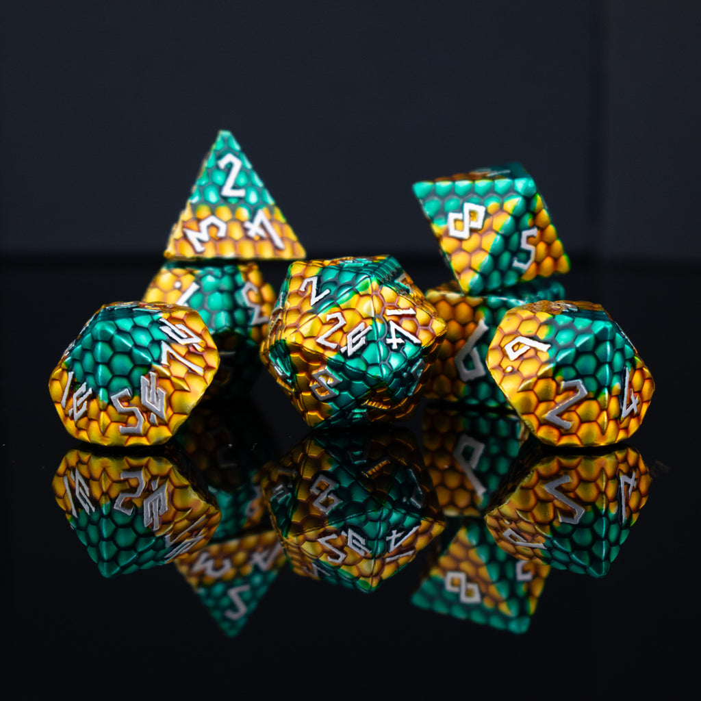 A set of green and gold dragon scale textured dnd metal dice with white numbering 