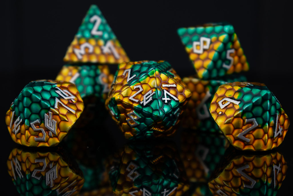 A set of green and gold dragon scale textured dnd metal dice with white numbering 