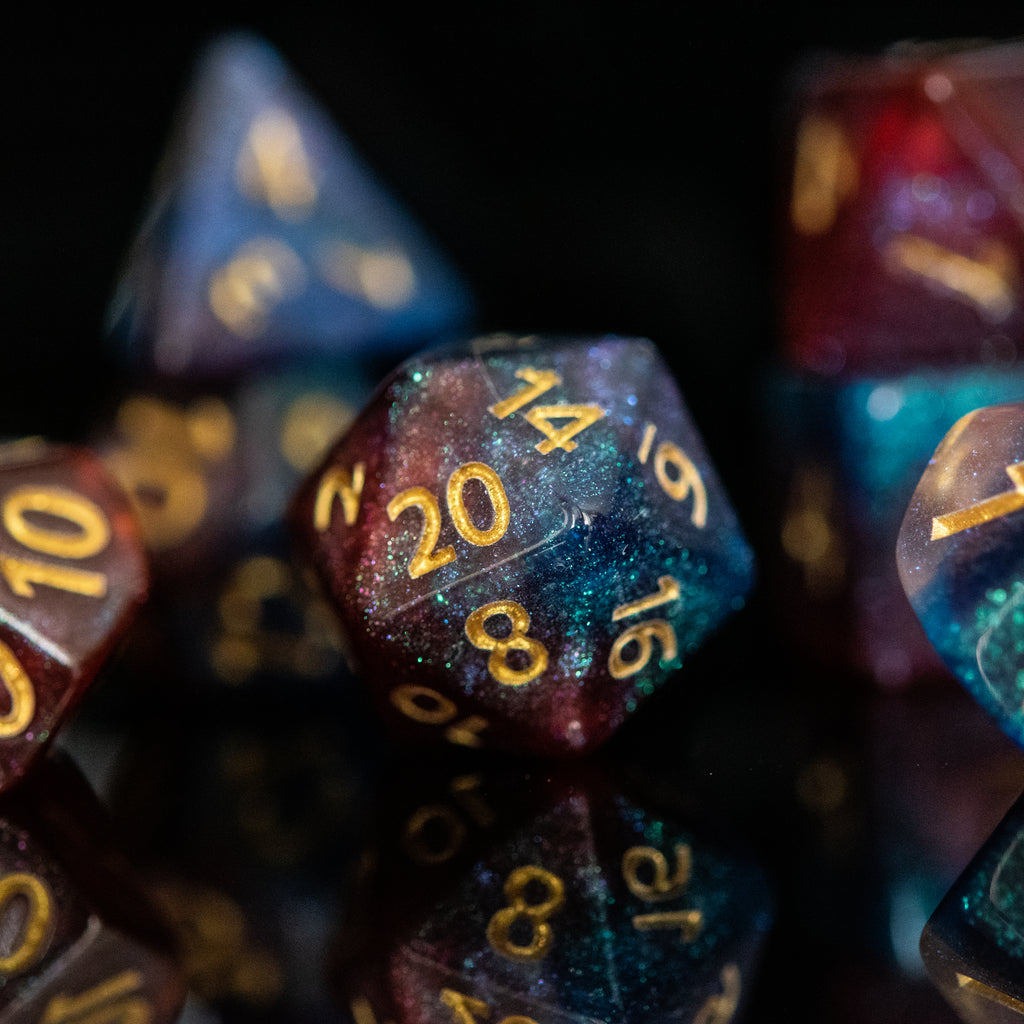 A set of multicolored acrylic dice with engraved numbers, displayed against a reflective background.