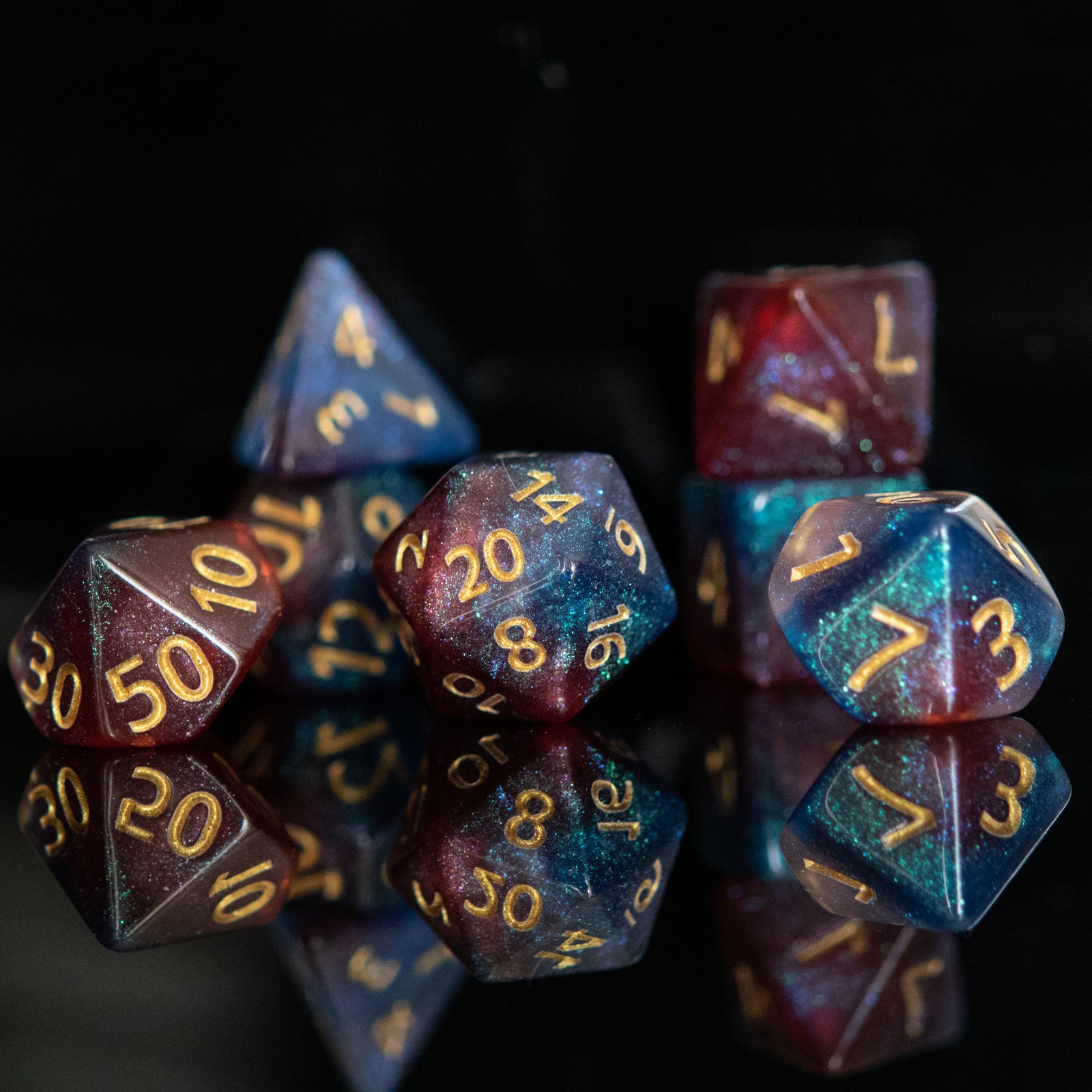 A set of multicolored acrylic dice with engraved numbers, displayed against a reflective background.