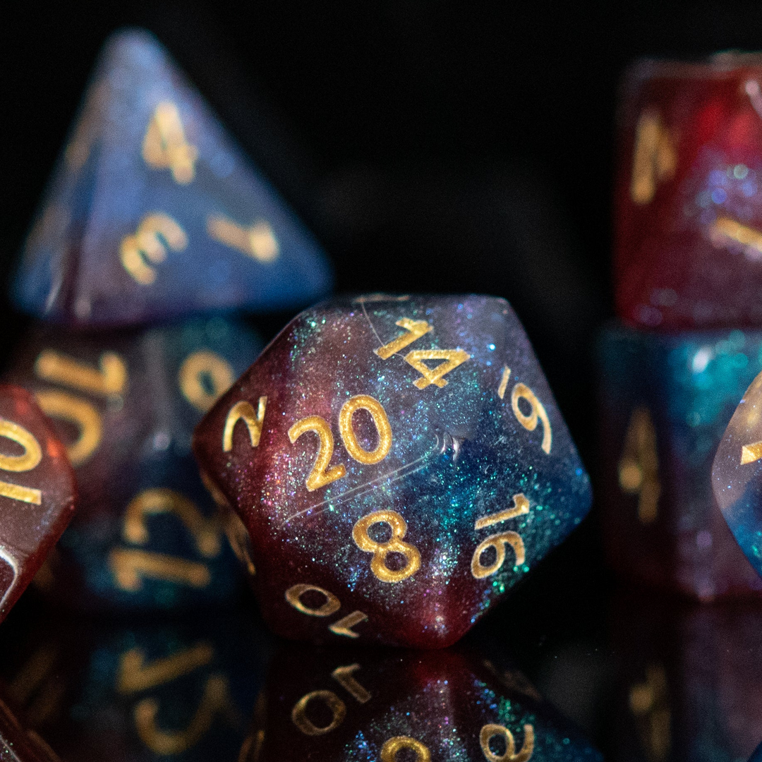 A set of multicolored acrylic dice with engraved numbers, displayed against a reflective background.