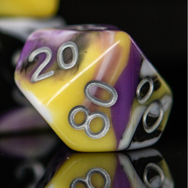 Polyhedral dice with purple and yellow colors and silver numbers on a reflective surface.