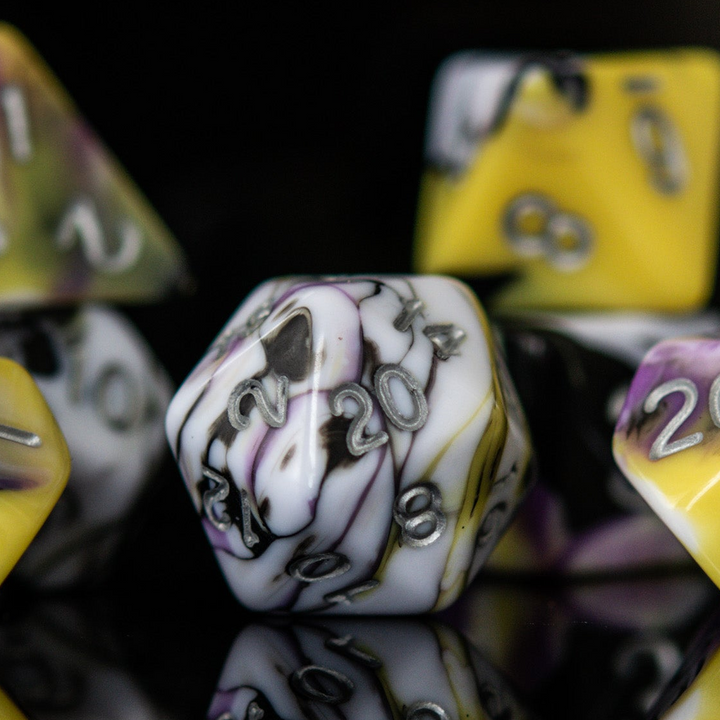 A set of acrylic dnd dice with black, white, yellow, and purple colors, featuring engraved silver numbers.