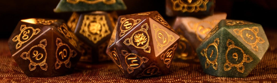 A set of hand-carved Indian Agate stone dnd dice with engraved patterns, displayed on a wooden surface.