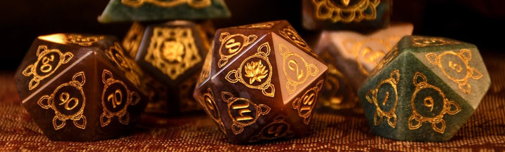A set of hand-carved Indian Agate stone dnd dice with engraved patterns, displayed on a wooden surface.