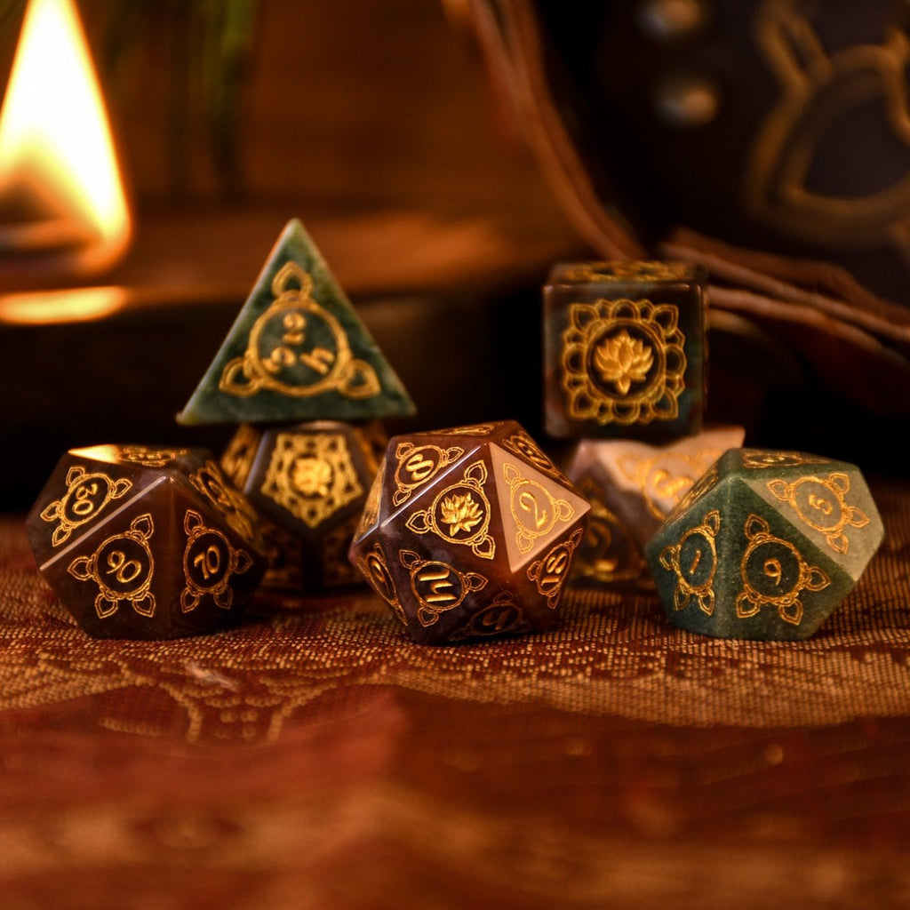 A set of hand-carved Indian Agate stone dnd dice with engraved patterns, displayed on a wooden surface.