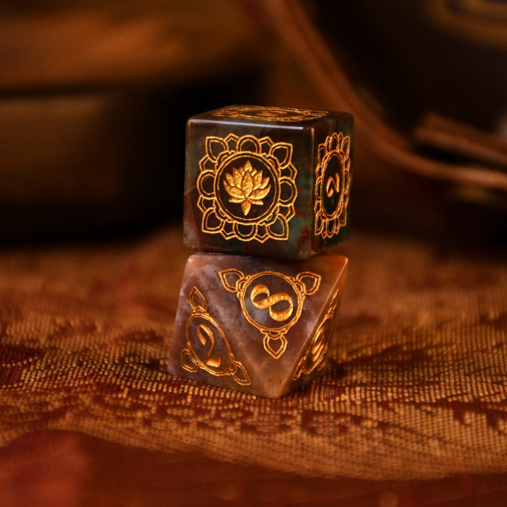 A set of hand-carved Indian Agate stone dnd dice with engraved patterns, displayed on a wooden surface.