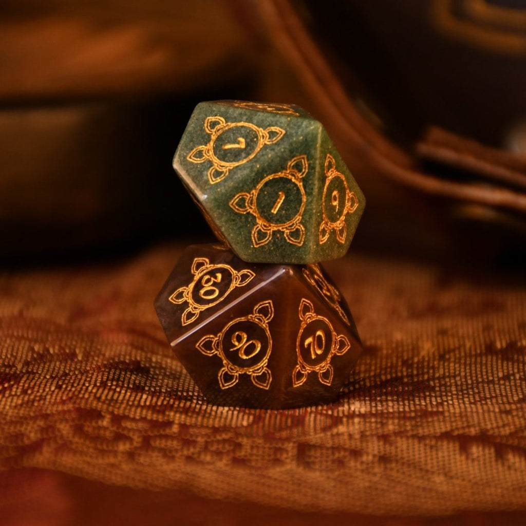 A set of hand-carved Indian Agate stone dnd dice with engraved patterns, displayed on a wooden surface.