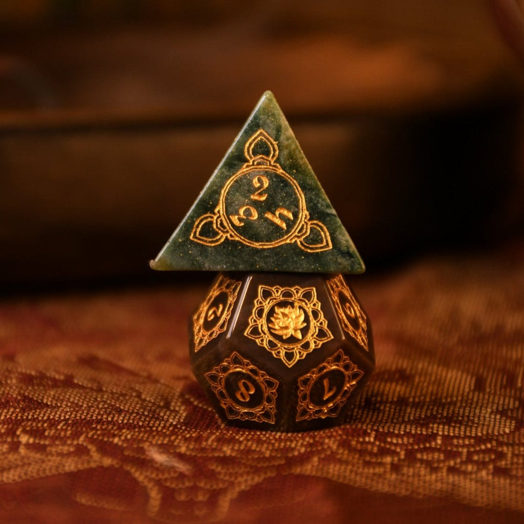 A set of hand-carved Indian Agate stone dnd dice with engraved patterns, displayed on a wooden surface.
