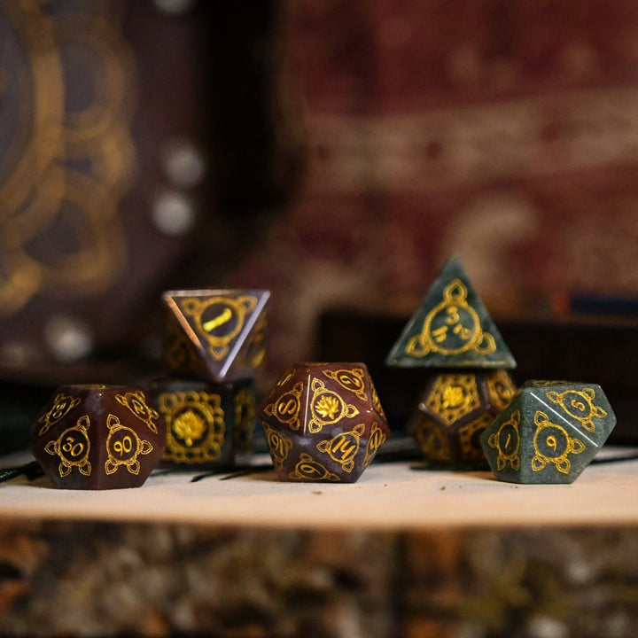A set of hand-carved Indian Agate stone dnd dice with engraved patterns, displayed on a wooden surface.