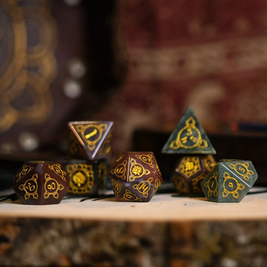 A set of hand-carved Indian Agate stone dnd dice with engraved patterns, displayed on a wooden surface.