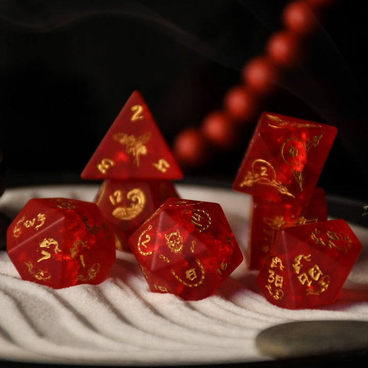 A set of hand-carved polyhedral Japanese Frosted Red Glass dnd dice with golden numbering and patterns. 
