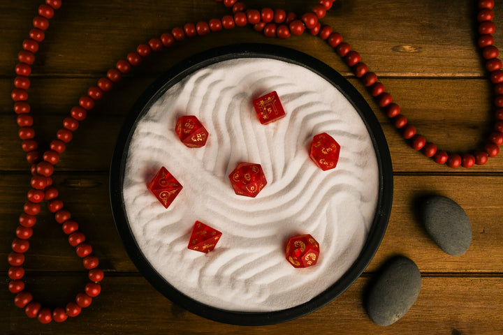 A set of hand-carved polyhedral Japanese Frosted Red Glass dnd dice with golden numbering and patterns. 
