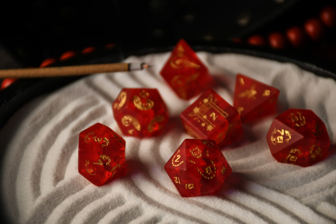 A set of hand-carved polyhedral Japanese Frosted Red Glass dnd dice with golden numbering and patterns. 