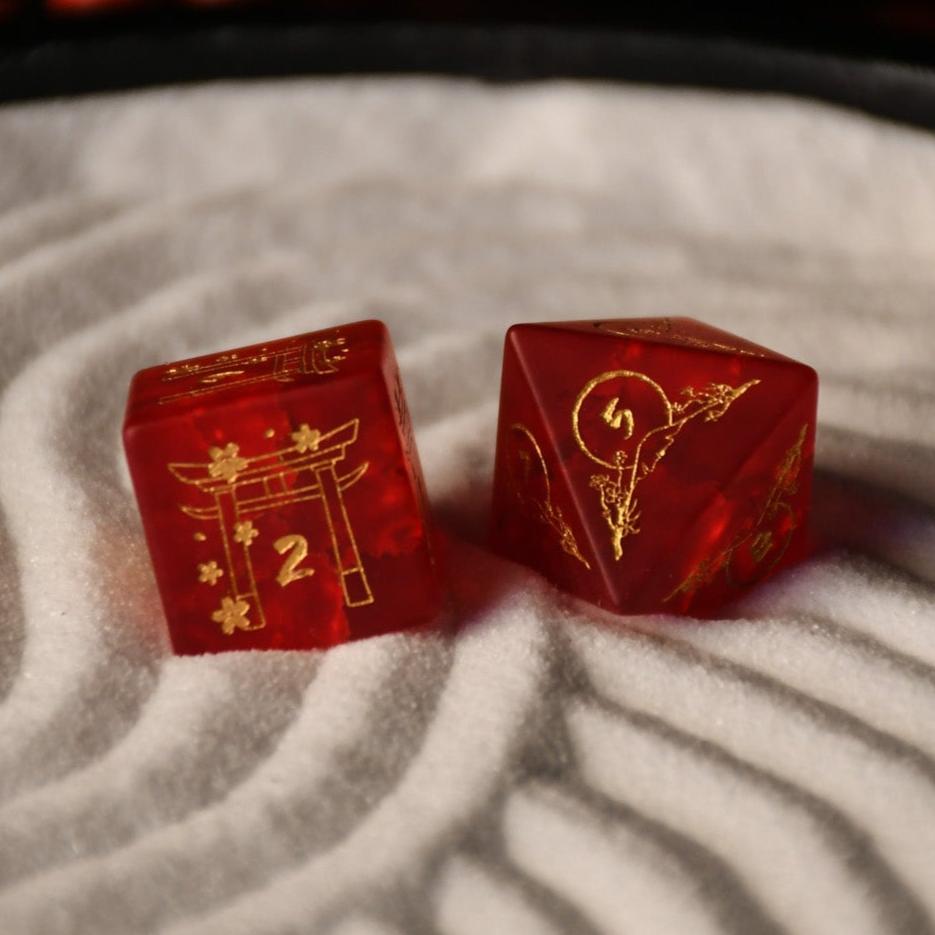 A set of hand-carved polyhedral Japanese Frosted Red Glass dnd dice with golden numbering and patterns. 