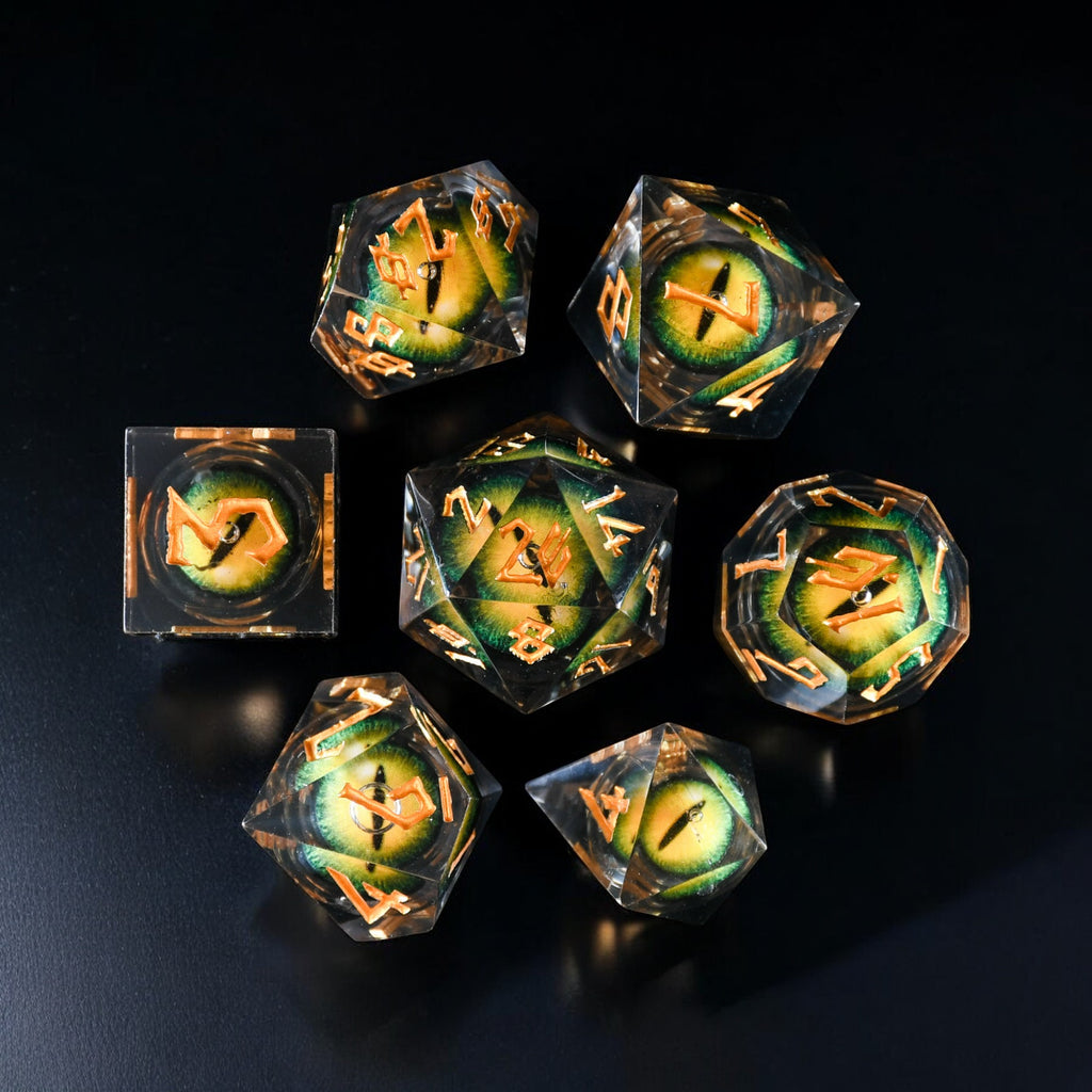 A set of yellow resin liquid core dice with green dragon eyes for tabletop gaming