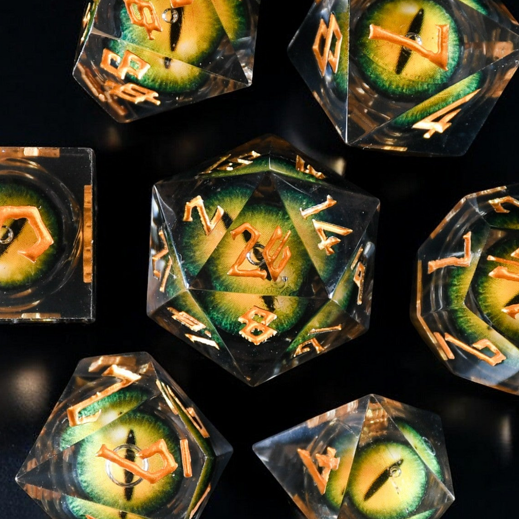 A set of yellow resin liquid core dice with green dragon eyes for tabletop gaming