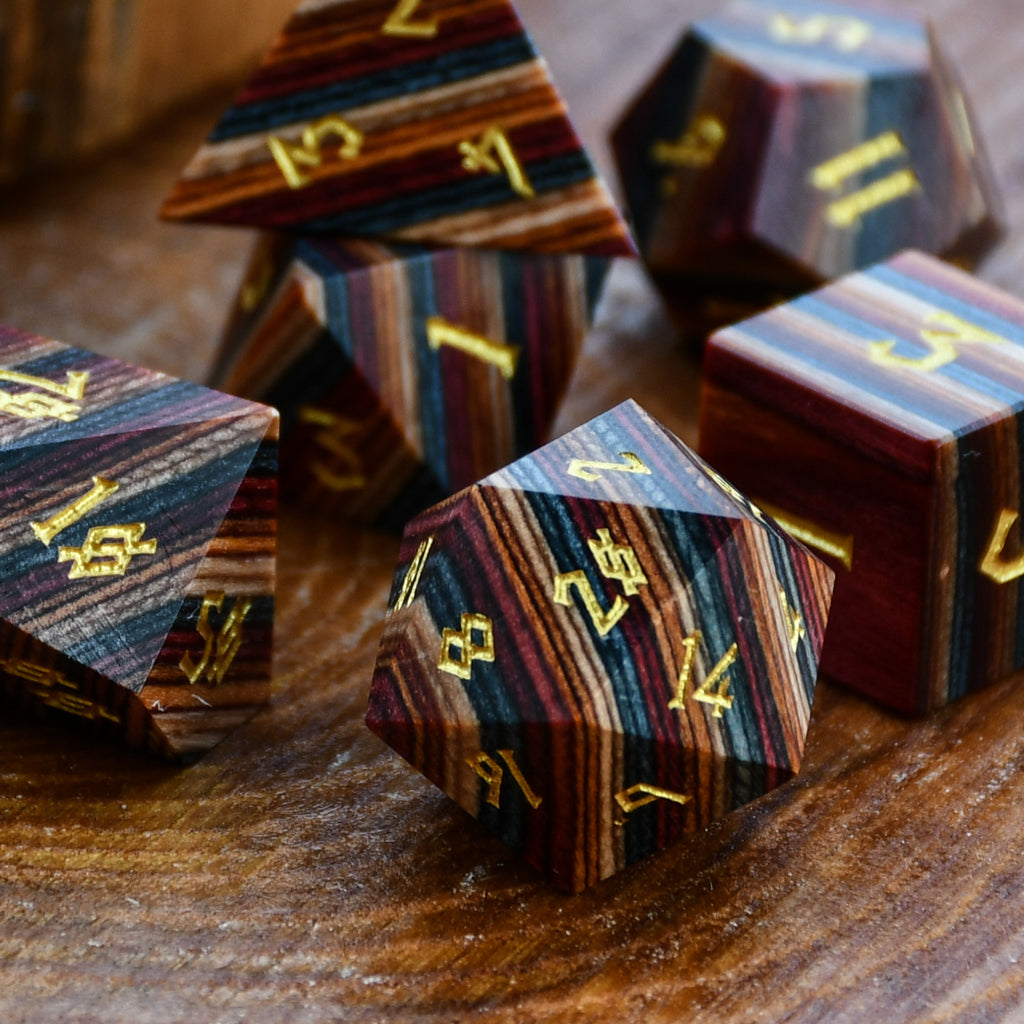 Wooden dice with gold numbering on a wooden surface