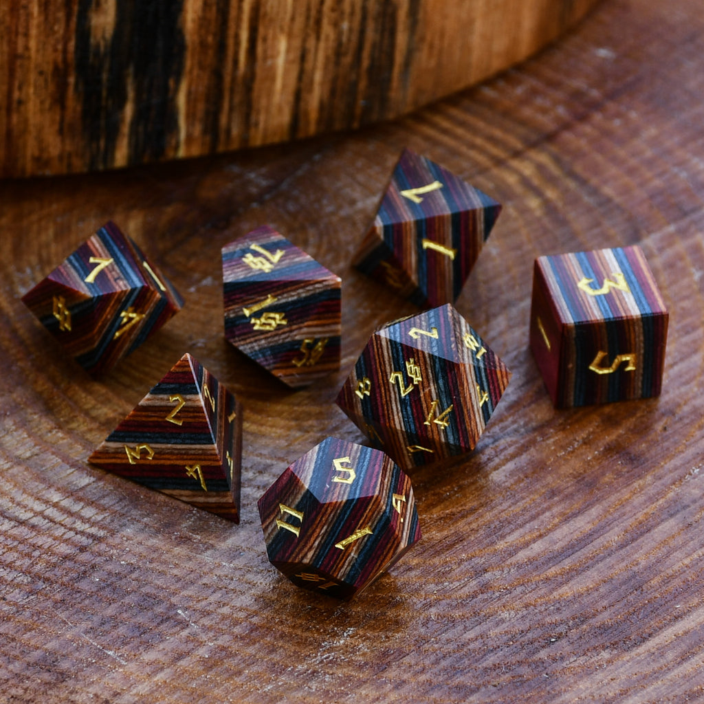 Wooden dice with gold numbering on a wooden surface