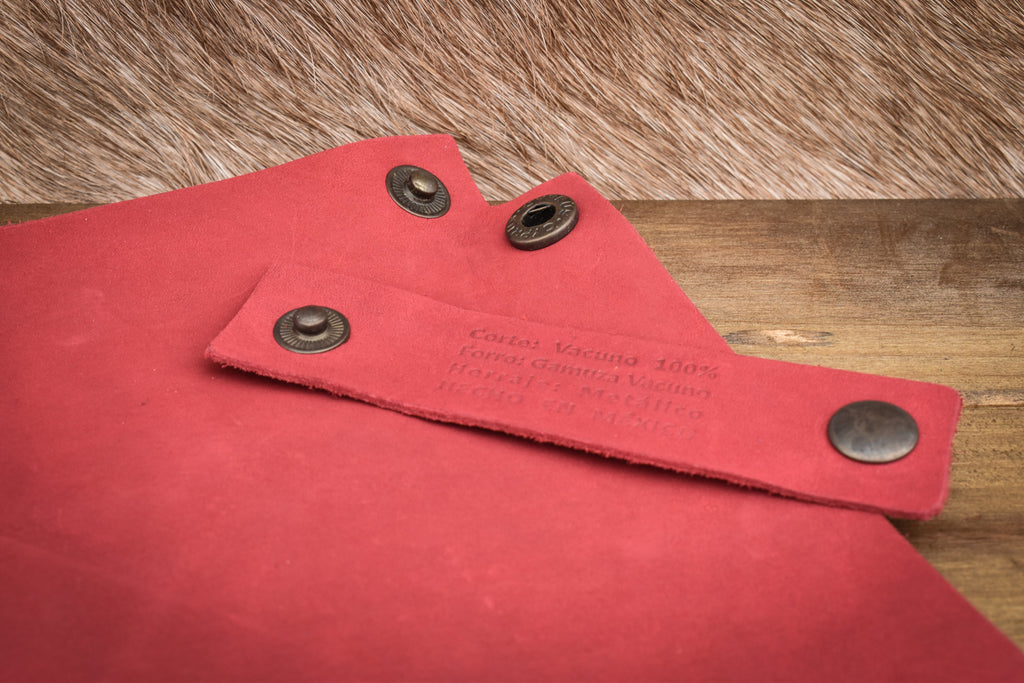 A red leather collapsible dice tray on a wooden surface, with the tray both folded and unfolded showing the compact and expanded states.