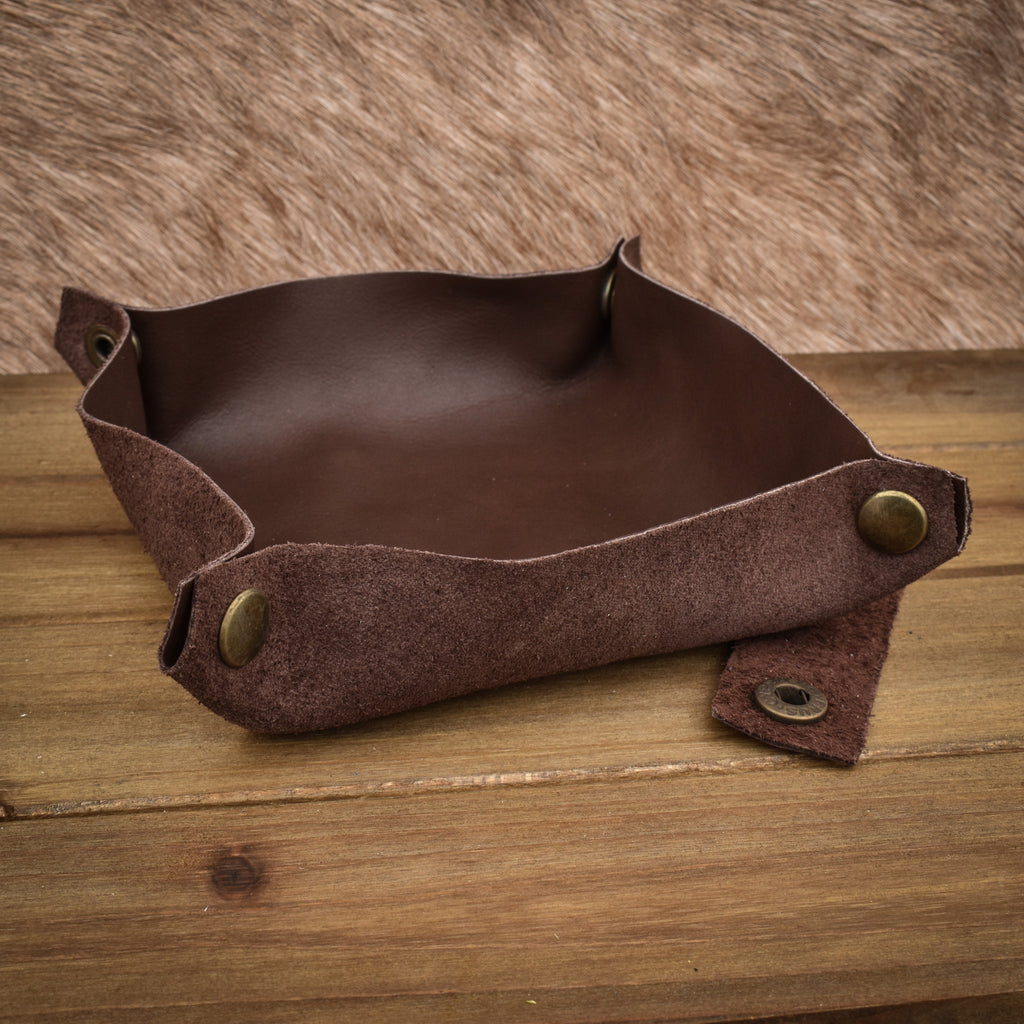 A semi-gloss brown leather collapsible dice tray displayed on a wooden surface.
