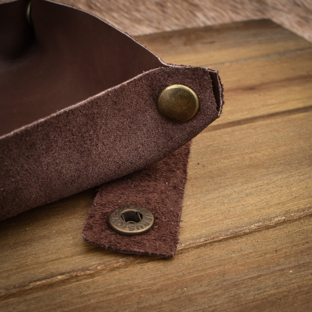 A semi-gloss brown leather collapsible dice tray displayed on a wooden surface.