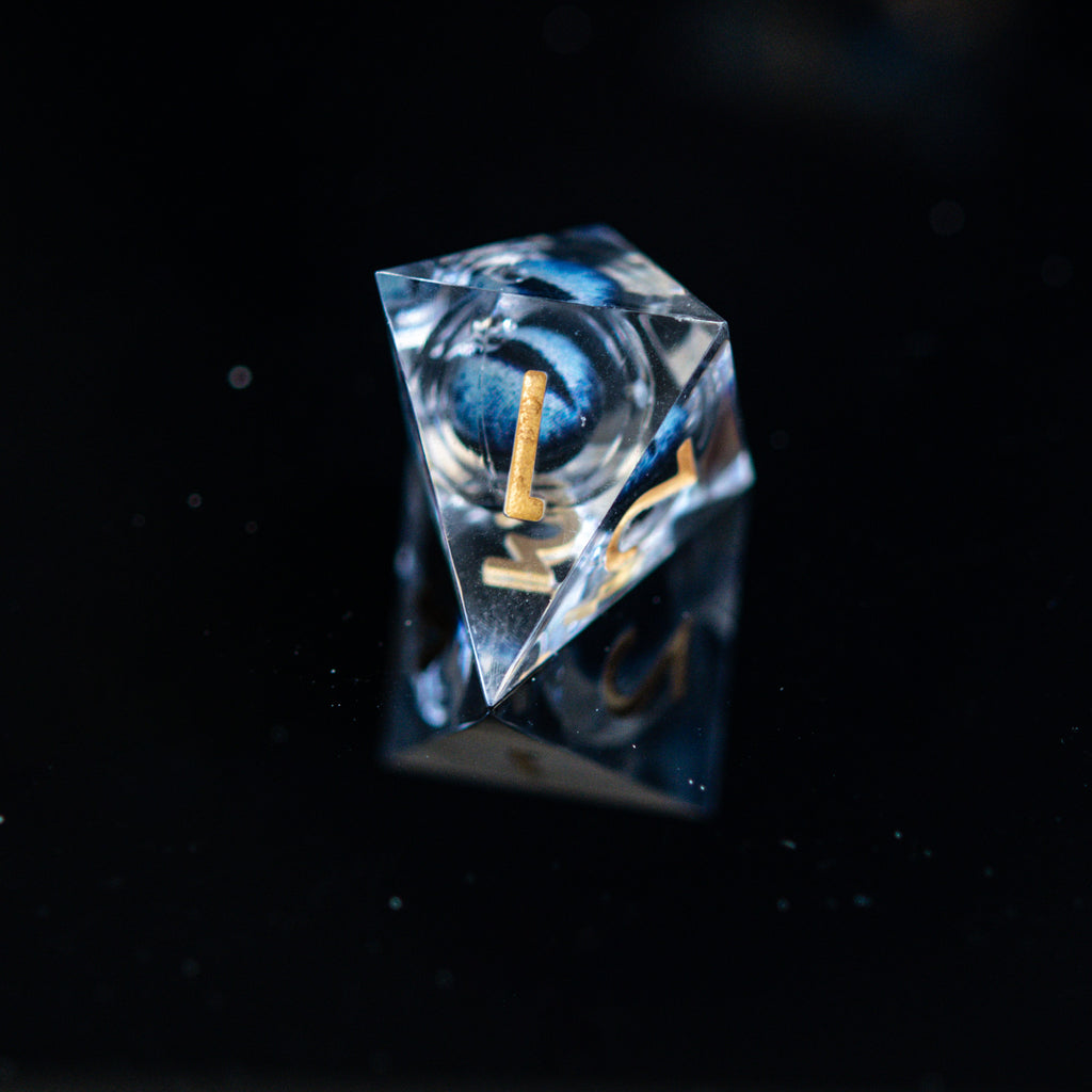 Close-up of polyhedral dice stacked with blue and gold numbers and a floating dragon eye inside on a reflective surface.