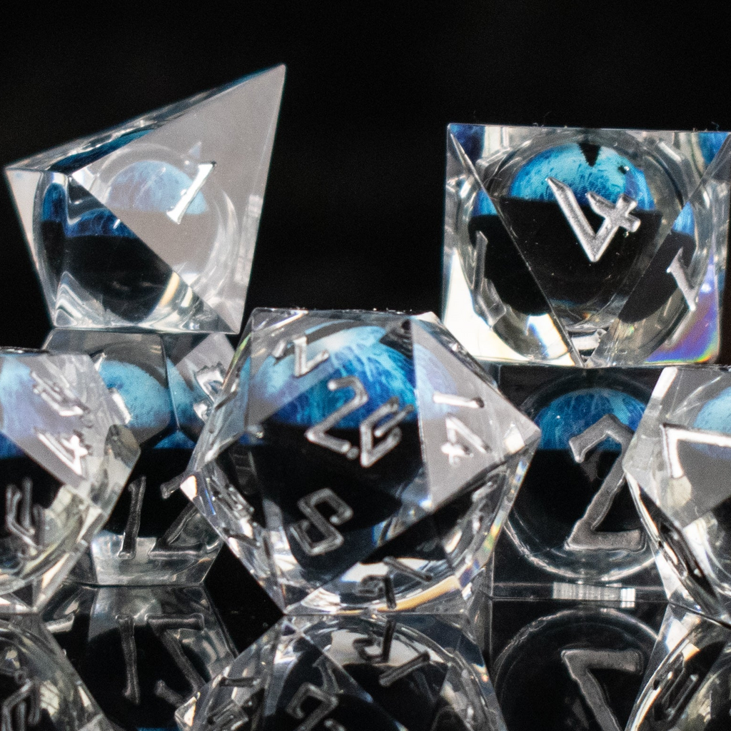 Clear polyhedral dice with blue and black numbers on a black background