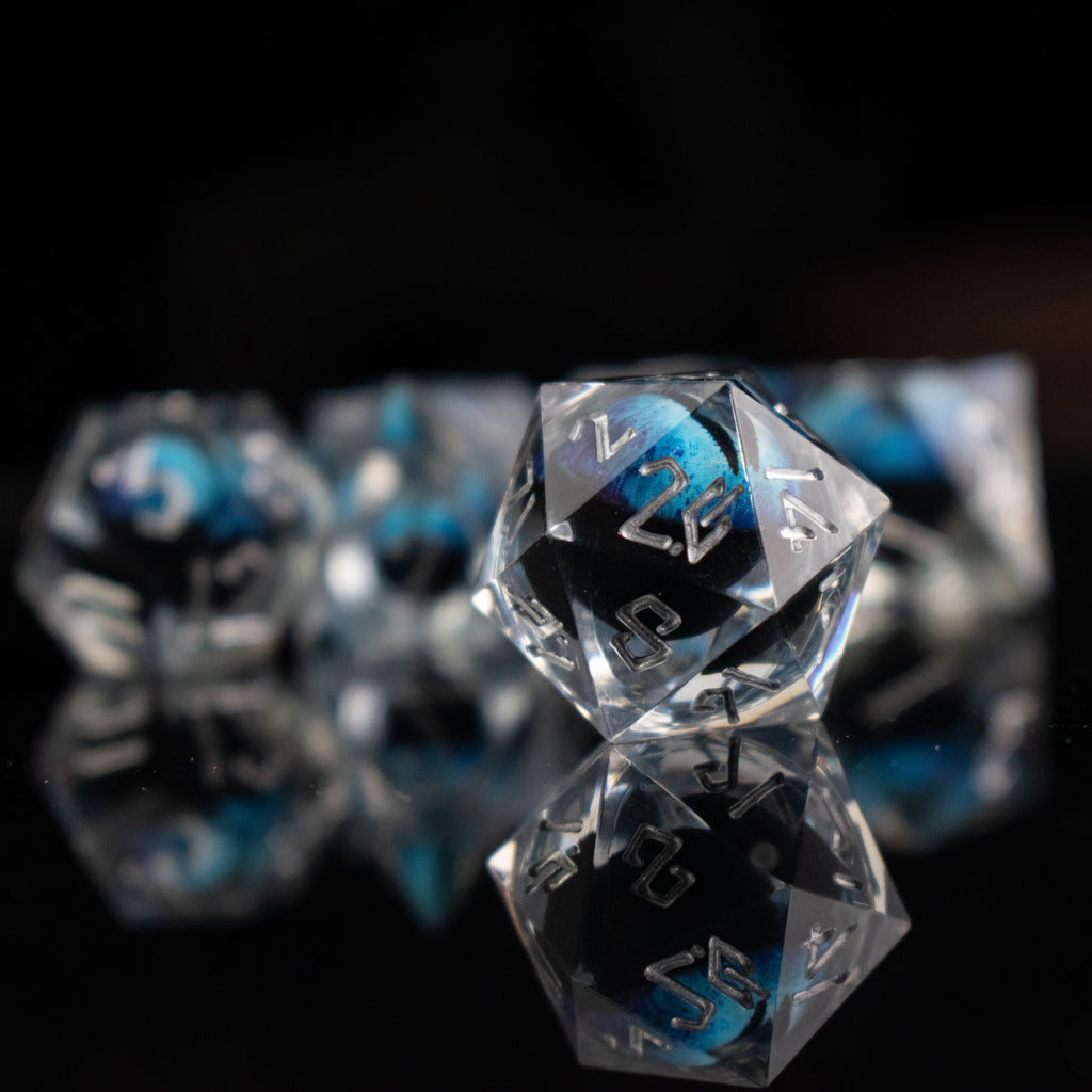 Clear polyhedral dice with blue and black numbers on a black background